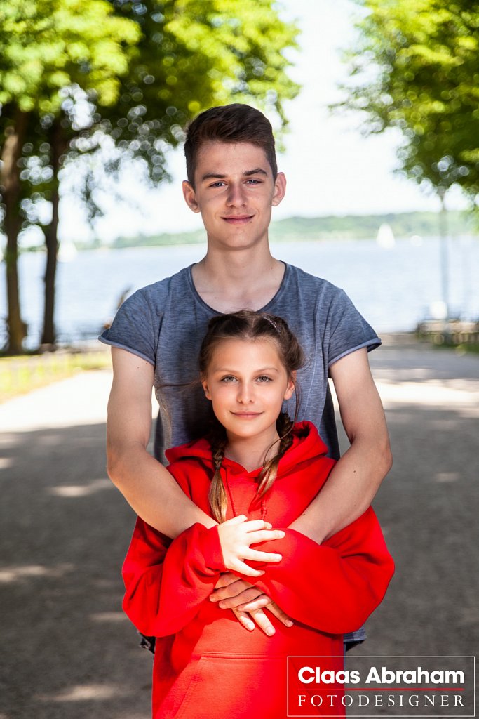 Zwei Kinder bei einem Fototermin draußen im Park.